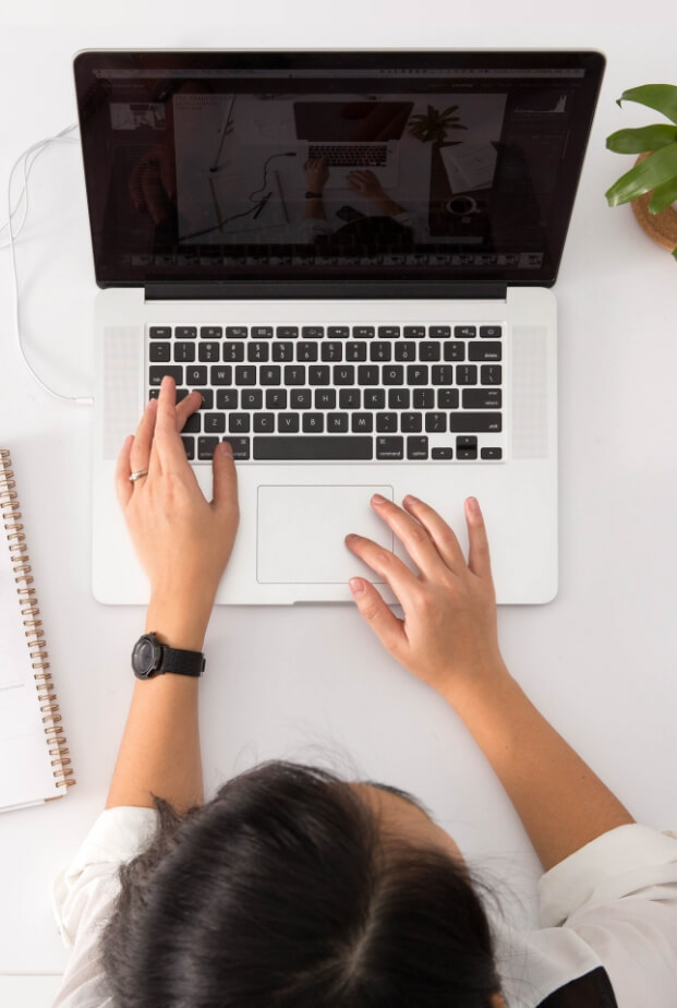 A person sitting at a desk with their laptop.