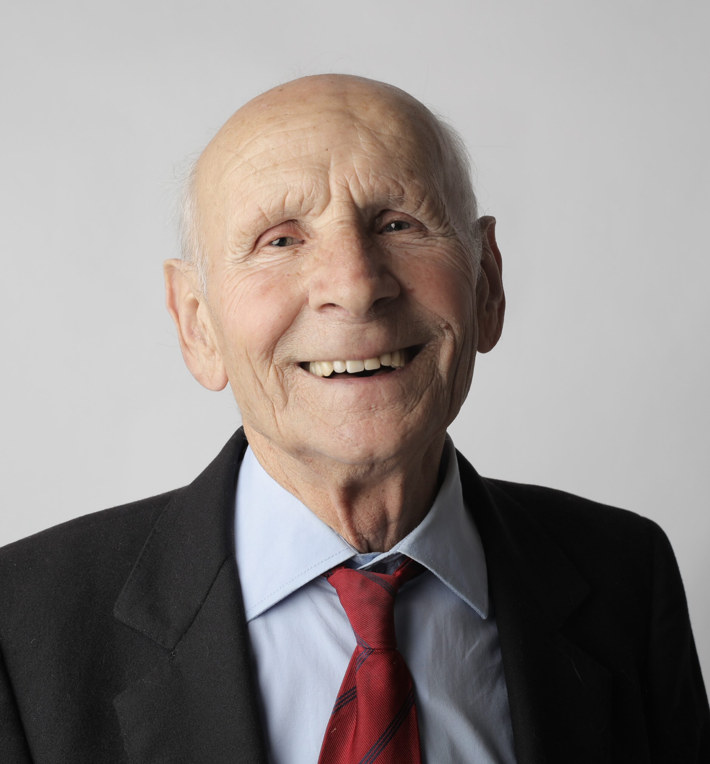 A man in a suit and tie smiling for the camera.